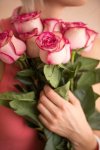 pngtree-unrecognizable-woman-holding-bouquet-of-pink-roses-she-is-very-satisfacted-photo-image...jpg