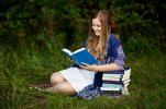 brown+haired+senior+girl+in+a+white+dress+and+a+blue+paisley+cardigan+sitting+in+a+grass+field...jpg