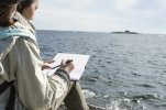 teenage-girl-writing-letter-at-seaside-JOHF06706.jpg